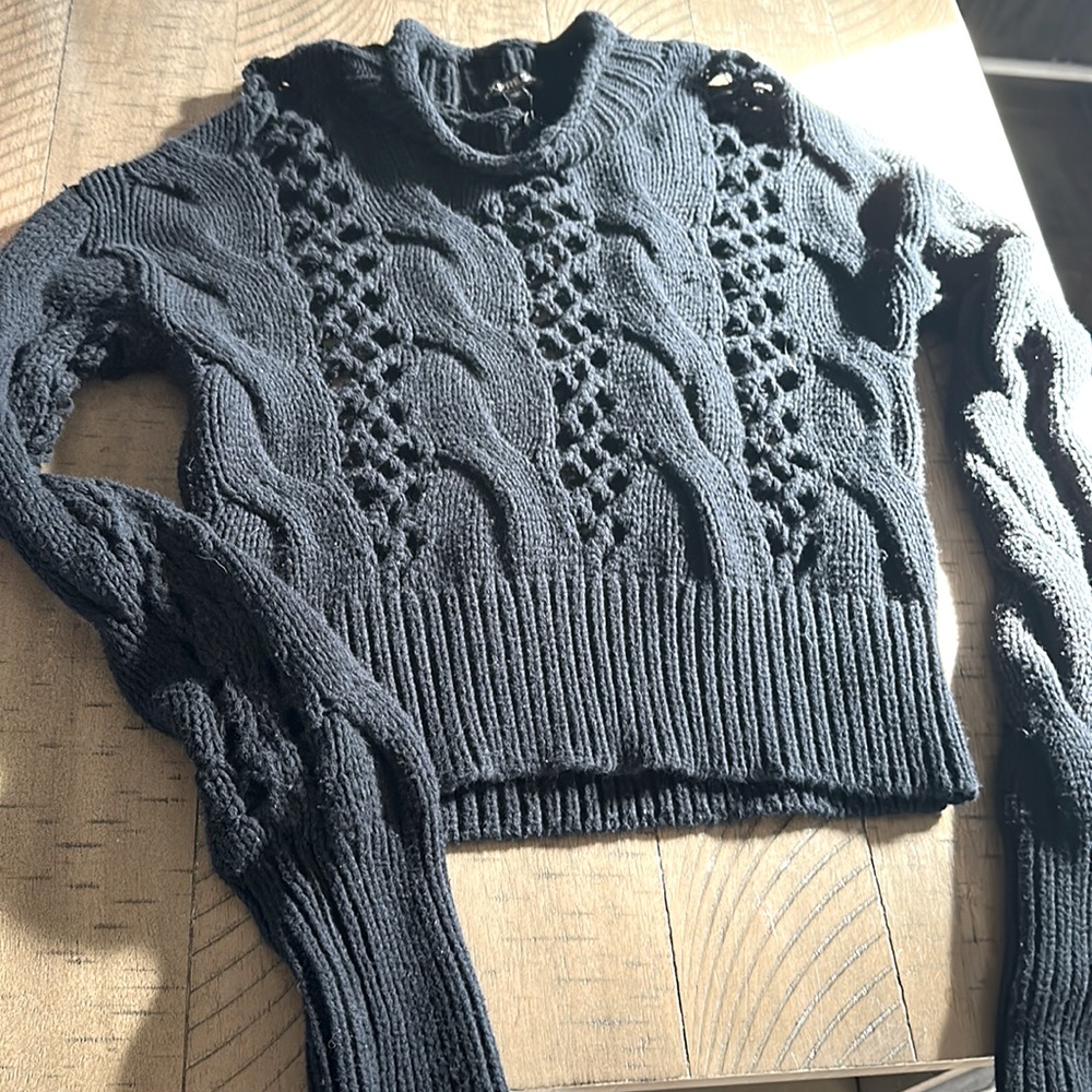 Black turtle neck sweater with see through holes.
